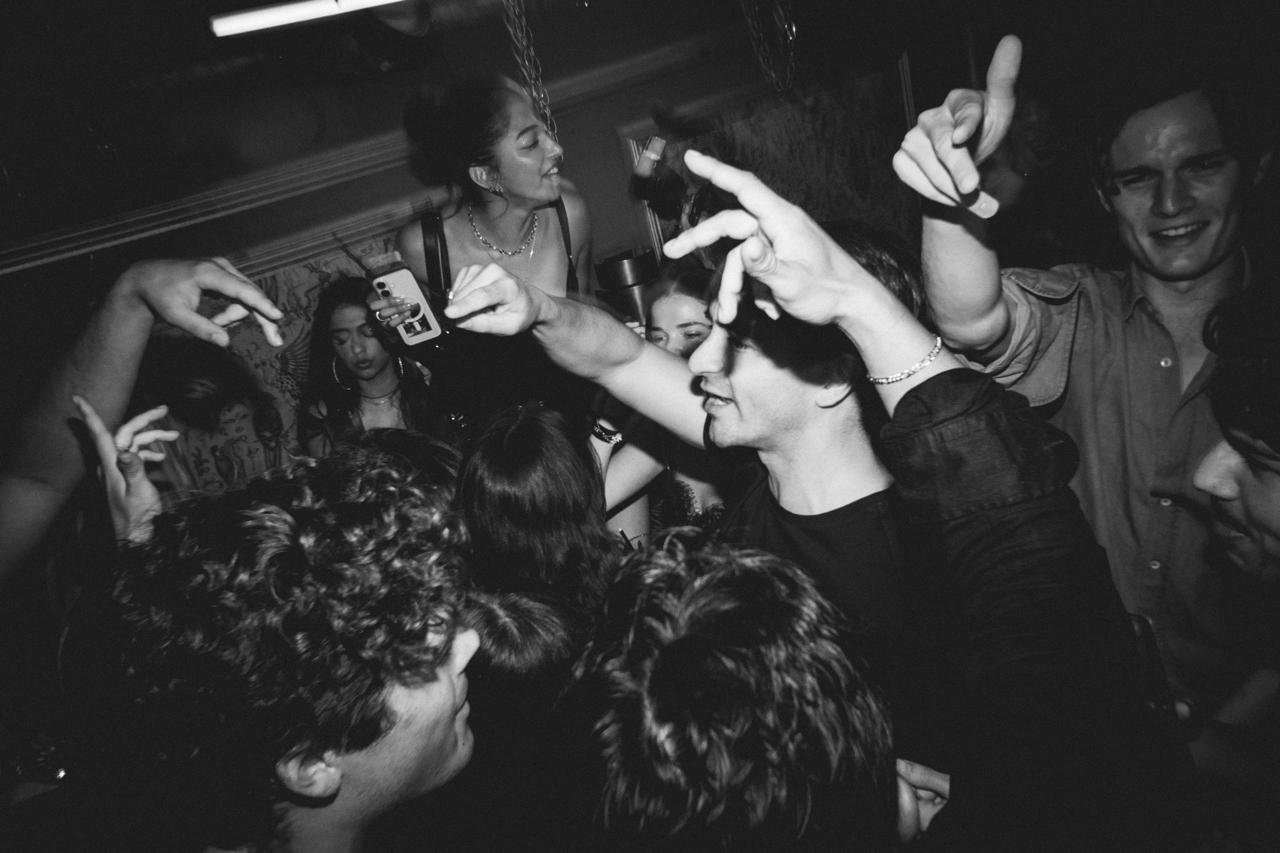 A tightly packed crowd dancing together in black and white